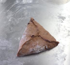 翻面后如图像包糖三角一样整形成三角形，捏紧