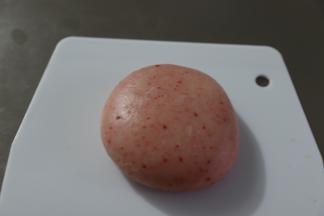 收口向下放在刮板上，用手掌按压扁平