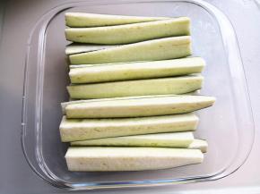 2.	取一只耐高温的容器，将切好的茄子条整齐地摆放在里面，