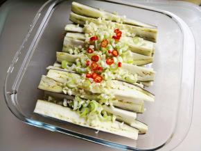 8.	将大蒜末、葱花、小米辣放到茄子上，