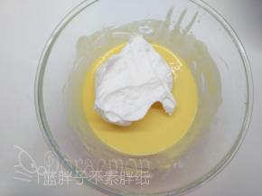 将1/3的蛋白霜加入到蛋黄糊中，用橡皮刮刀翻拌均匀