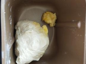 3、揉成团后加入黄油继续揉。