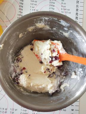 6、这时候可以做奶酪馅，蔓越莓切碎，将奶酪和糖粉混合用打蛋器打顺滑，在加入蔓越莓干拌匀，装入裱花袋