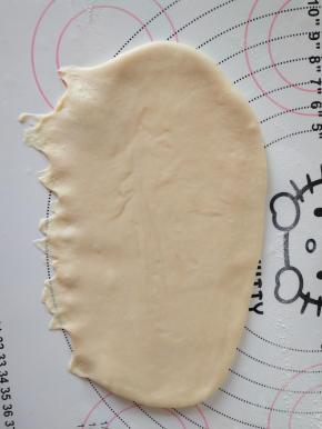 7、取一个面团擀开，擀成椭圆形。