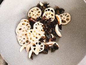 锅中倒少许油烧热，放入口蘑，莲藕，木耳翻炒。