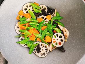 倒入荷兰豆，红萝卜，翻炒均匀。