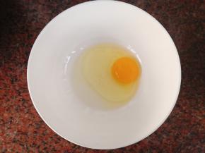 碗中打入一个鸡蛋，打散放少许盐拌匀。