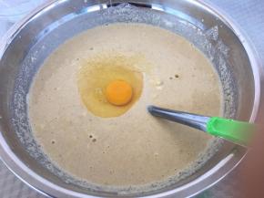 将打好的米浆里打入一个鸡蛋、放入3克酵母、少许白糖、加入100克面粉搅成糊状。