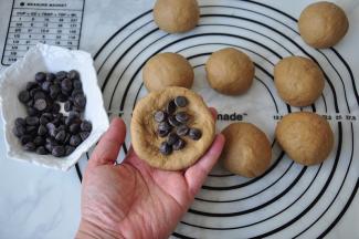 我把面团排气后分成了10个又滚圆，然后压扁再包入了巧克力豆，您也可以放入自己喜欢的馅料，如果是较冷的季节，您可以全部包好醒发20至30分钟左右。但夏天温度高，就可以包好后直接烤。