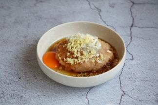 将鸡肉泥放在一个较大的容器里，放入1个鸡蛋、少许的白胡椒粉、1勺的料酒、淀粉2勺、1小勺的生抽、葱花姜末各5g。

