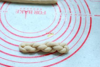 别急，这样还没完，仍然是反方向上劲，再提起两端对折，自然地扭成一个小麻花的形状，好了，这样才算是完成一个麻花。这一步小心断裂，不过，饧发好的米面团是不会断裂的。