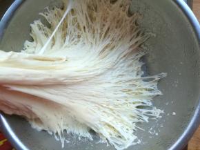 第一步我们先来发面，面粉内加入酵母、温水，先用筷子搅拌成雪花状，然后再用手揉成光滑的面团，放在温暖的地方发酵。等到面团发酵到2倍大，拉开面团，内部充满气孔，闻一闻面团有发酵的香气，这样的面团就发酵好了。