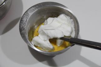 蛋白霜取1/3入蛋黄糊中，用刮刀从中心点切入从底部往盆边翻起到中心点，翻拌均匀。