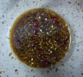 将4勺酱油、3勺醋、2勺糖、蒜泥、盐和小米辣倒入小碗中，拌匀。