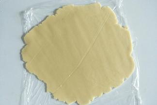 冷藏好的面团上下垫油纸，擀成厚度为3mm左右的薄饼。