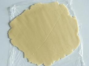 冷藏好的面团上下垫油纸，擀成厚度为3mm左右的薄饼。