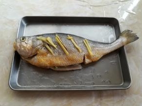把黄花鱼放到蒸鱼的盘子里，鱼身上和鱼肚子里都淋一点点料酒，鱼身的正反两面都要淋到，腌制10分钟