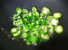 锅里热油放入盐、糖煸香再放入青椒圈