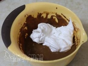 先将1/3的蛋白霜加入可可面糊中，用刮刀翻拌均匀。
