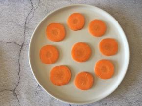 胡萝卜洗净去皮切成薄片，摆在盘中，再切一些碎胡萝卜备用。