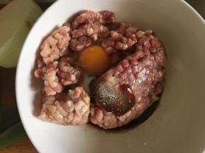 糯米提前加水浸泡4个小时以上，冲洗干净。把肉馅放到碗中，加入蚝油，生抽，盐，葱花，鸡蛋，料酒，用筷子将所有材料往一个方向搅拌上劲。