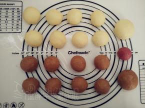 接着我们来分面团。白色面团先分出一个52g（做耳朵、手脚）的面团，剩下的均分为8个，每个约30g。棕色面团同样操作，将它们都滚圆之后盖上保鲜膜松弛15分钟。