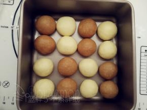 除做耳朵、手脚和爱心的三个小面团外  ，其余松弛好的面团压扁之后再次滚圆，一一摆入学厨8.5寸活底正方形模中。