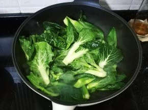 锅里热油放入盐糖，倒入菜心翻炒至8成熟