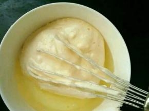 取适量翻拌好的蛋糕糊，放到牛奶和玉米油的混合物里，翻拌均匀。
