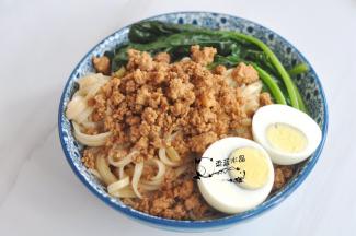 面条拌匀后，表面舀上肉燥，摆上菠菜，放上对半切开的鸡蛋，最后将汤汁淋在表面。