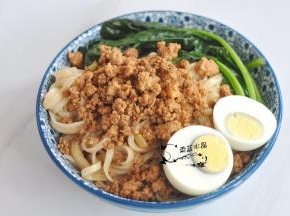 面条拌匀后，表面舀上肉燥，摆上菠菜，放上对半切开的鸡蛋，最后将汤汁淋在表面。