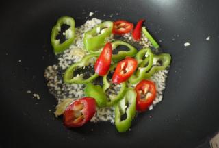 蒜姜爆香后加入青红椒，翻炒一下。