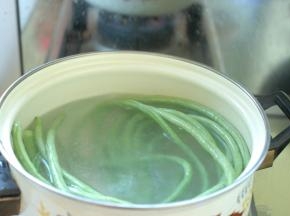 先把长豆角择洗干净，用盐水浸泡5分钟后，捞出来再冲洗两遍，豆角就清洗干净了。然后把锅里放入适量清水烧开，水开后加入1勺盐，1勺食用油，把把清洗干净的长豆角放入锅里，水开后大约煮3¬¬—5分钟，直到豆角煮软。