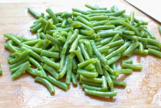 豆角捞出来，放在案板上，晾凉后切成差不多一个指节左右长短的小段，放在盆子中，加入盐、香油，用筷子搅拌均匀。豆角的长短完全看个人喜欢啊，你喜欢吃长一点的就切长点，也可以切成末，更入味。不用放更多的调味料，只放点盐和香油就已经很好吃了。