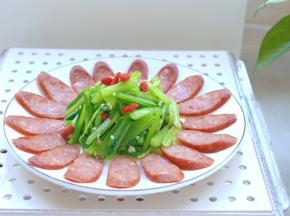 这时候牛肉肠也蒸好了，取出来，把拌好的根达菜放在盘子中间，点上几粒泡好的枸杞，一盘好吃好看、制作简单的根达牛肉肠就做好了，上桌开吃吧！