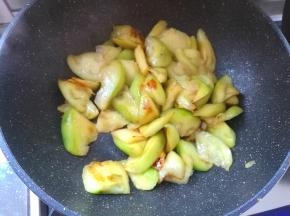 炒锅烧热，倒入适量的食用油，把腌制好挤出水分的茄子放进锅里，炒软，盛出来装盘待用。