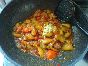 把调好的料汁倒进去，翻炒均匀，然后把茄子放进锅里，加入1勺盐，还有剩下的另一半蒜末，炒香。