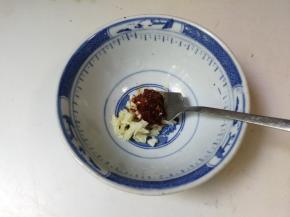 蒜瓣剥去皮拍成蒜末，放入一小勺辣椒酱