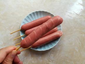 在热狗肠的左右2侧，用水果刀各划上6个小刀口，刀口不要太深