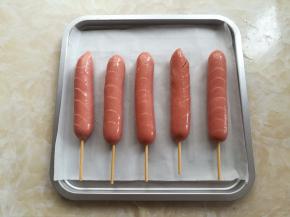 热狗肠放入烤盘里，刷一点点玉米油