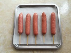 热狗肠放入烤盘里，刷一点点玉米油