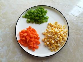 玉米剥出来清洗干净，胡萝卜刨皮后切成跟玉米差不多大，青椒去籽切小粒备用，切胡萝卜的时候就可以先把烤箱预热了，上下火180度5分钟