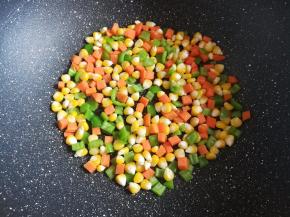 把切好的胡萝卜、青椒粒和玉米放入锅里炒干水分，不需要放油，这样可以避免烤披萨时候出水，被吐司片吸收水分