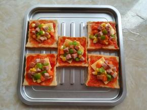 把炒好的蔬菜丁和香肠粒放到吐司片上，想放多少就放多少