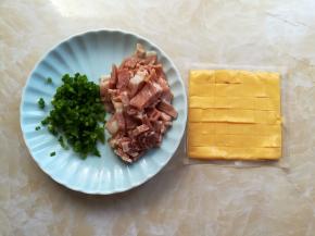 葱花洗净切成筷子尖大小的颗粒，培根对半切开再切成1厘米大小的小块，取一片芝士片切成指甲盖大小的小块