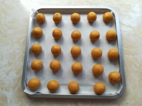 烤盘里垫一张油纸，把饼干面团按照10克每个分成24个，揉圆一下