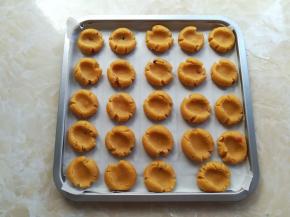 用大拇指在饼干球上按下一个坑，先刷一层薄薄的蛋液