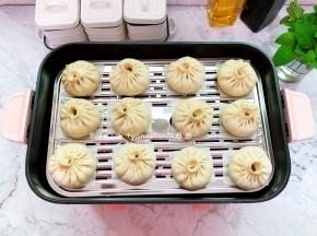 把包好的包子放在多功能锅的蒸笼上，多功能锅此时可以加入水开小火微微加热，让整个锅体以及内部温热湿润，放的时候要留出空间来，以免发酵的时候包子都挤在一起了，多功能锅关火