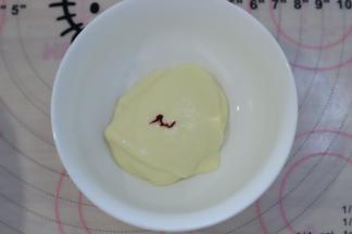 取少许的蛋糕糊，加入一滴红色食用色素，混合均匀后装入裱花袋。