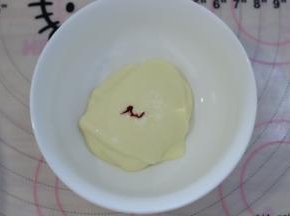 取少许的蛋糕糊，加入一滴红色食用色素，混合均匀后装入裱花袋。